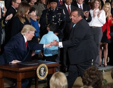 Gov. Christie leans in to hand President Trump a pen