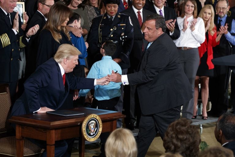 Gov. Christie leans in to hand President Trump a pen