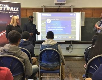 Eagles player Malcolm Jenkins (center left) speaks about financial literacy to students at Bodine High School in Philadelphia (Avi Wolfman-Arent/WHYY)