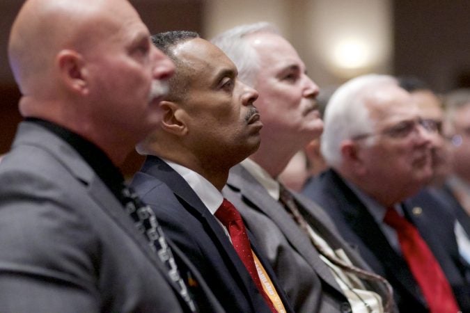 Men listen as Sessions speaks out of frame