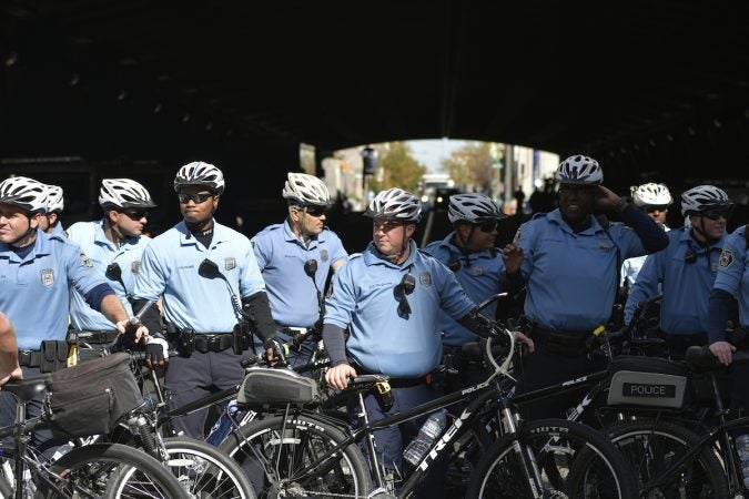 Bycicle officers stand blocking a street