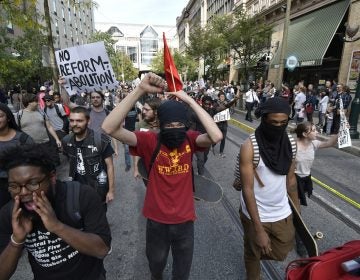 Masked protesters march through the city streets