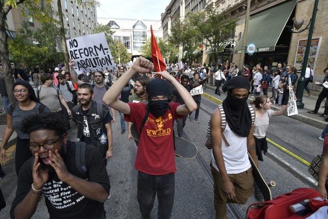 Masked protesters march through the city streets