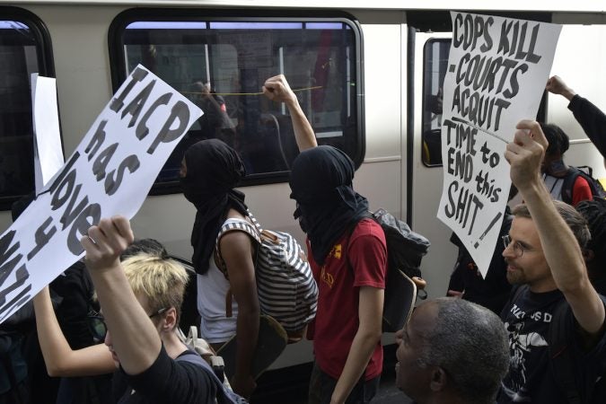 A SEPTA bus passes by a group of protesters