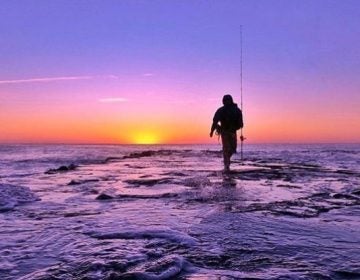 An angler walks a jetty in Asbury Park. (Photo: Suzanne Spitaletta)