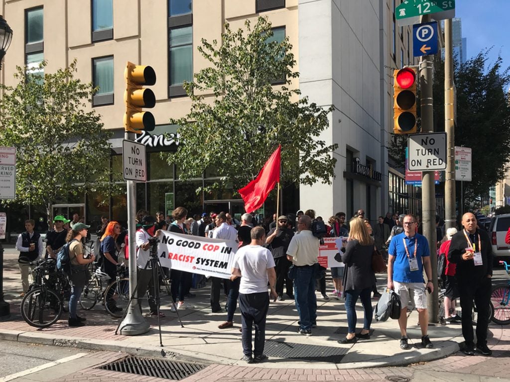 People stand with signs and chant