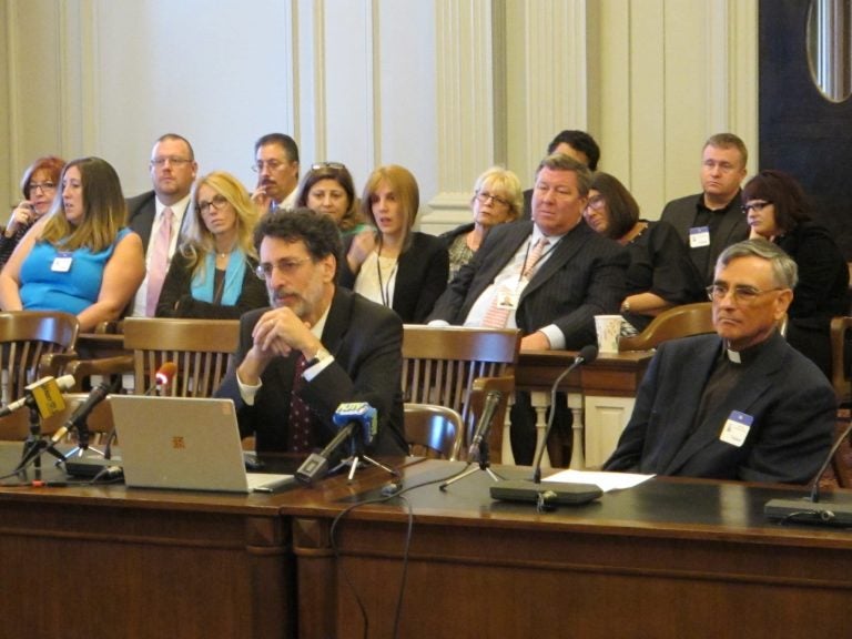 People sit at a table and in the audience during a hearing at the New Jersey Legislature