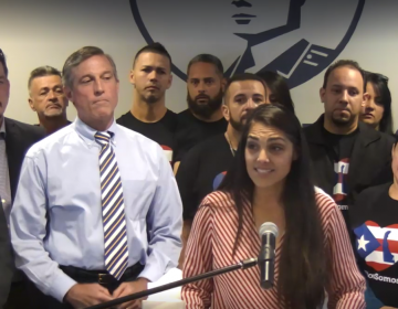 Delaware Hispanic liaison India Colon stands in front of Gov. John Carney as she talks about the devastation she saw in Puerto Rico after Hurricane Maria. (screenshot via Delaware.gov/Livestream)