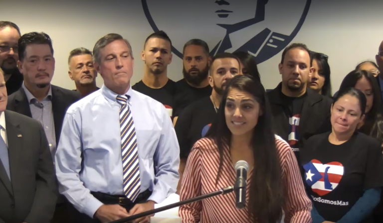 Delaware Hispanic liaison India Colon stands in front of Gov. John Carney as she talks about the devastation she saw in Puerto Rico after Hurricane Maria. (screenshot via Delaware.gov/Livestream)