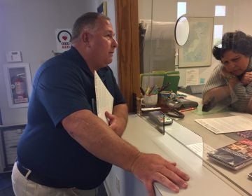 A man stands at a window in a municipal building in New Jersey