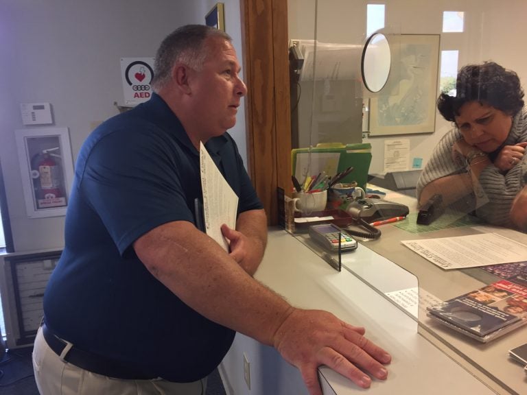 A man stands at a window in a municipal building in New Jersey