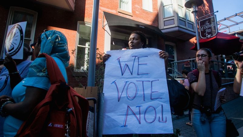 A closeup of the woman with the 'we vote no sign'