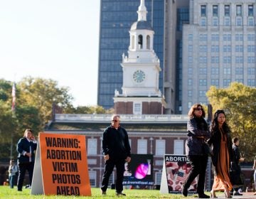 Visitors of Independence Mall in Philadelphia walk past signs both depicting and warning of graphic images. Created Equal, the anti-abortion group that is Columbus, Ohio-based, sponsored the protest. (AP Photo/Matt Rourke)