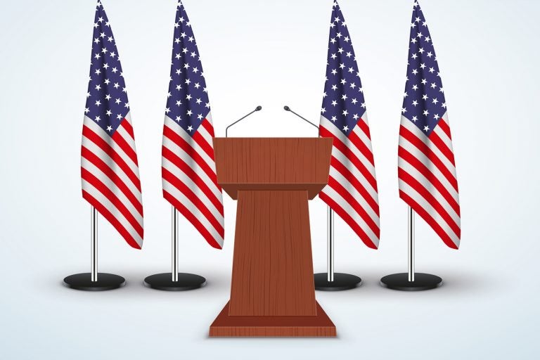 Wooden Podium Speaker Tribune with United States flags on background.