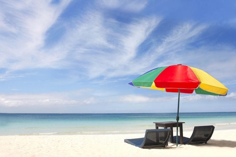 umbrella and chairs on white sand beach (volare2004/BigStock)