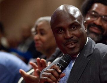 Solomon Jones, co-moderator, seated with a sub-panel, during Courageous Conversations: Reimagining Race and Education forum at Enon Tabernacle Church, on Thursday night. (Bastiaan Slabbers for WHYY)