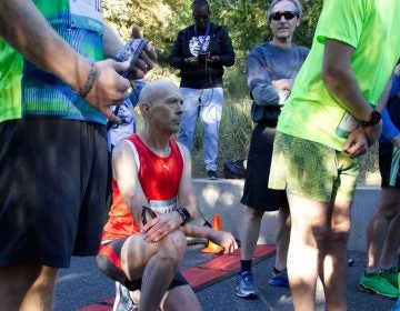 Kevin Peter, of West Mt. Airy, takes a knee in protest during the National Anthem at the start of the WXPN 5K, on Sunday. (Bastiaan Slabbers for WHYY)
