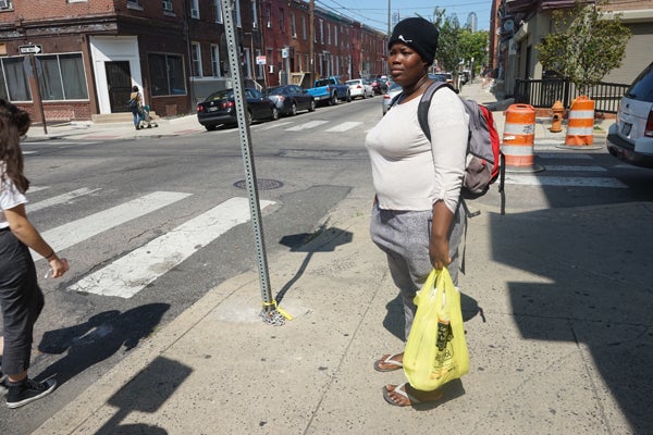 Tatiana Angama on the street corner where she waits for the van that takes her to her produce packing job. (Harvey Finkle)