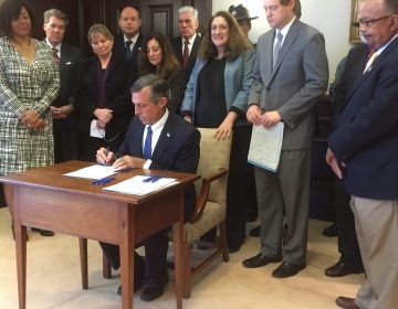 Delaware Gov. John Carney signs several bills to reform the state's juvenile justice system. (Zoë Read/WHYY)