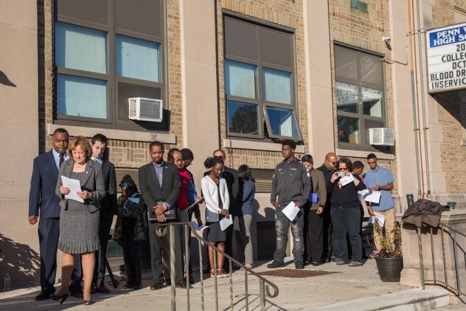 Wide shot of people outside of a school