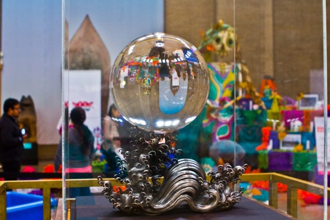 The Day of the Dead altar reflects through the Crystal Sphere on display at the Penn Museum. (Kimberly Paynter/WHYY)