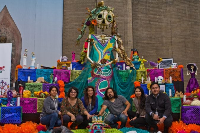 Artist Cesar Viveros (center right), coordinated the effort of his pupils and employees of the Mexican Consulate to create the altar. (Kimberly Paynter/WHYY)