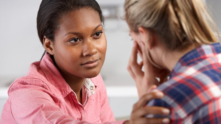 A woman reaches out to help another woman.