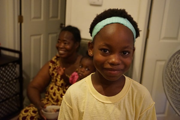 Grace Angama, 9, in the foreground. Her mother, Giselle, 51, and Giselle’s granddaughter, Ellary, 2, are seated in the background at their apartment in South Philadelphia. (Harvey Finkle)