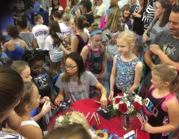 Young woman, surrounded by other girls, onlookers