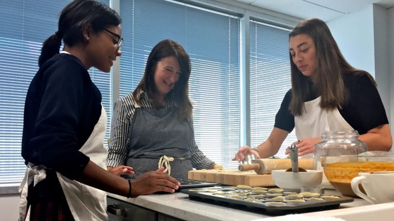 Three female high-schoolers working in a test kitchen, baking equipment, rolling pin on counter