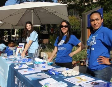 Workers in matching blue tshirts man a table in Philadelphia