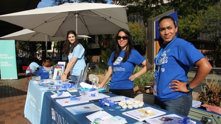 Workers in matching blue tshirts man a table in Philadelphia