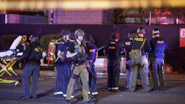 Police officers and medical personnel stand at the scene of a shooting near the Mandalay Bay resort and casino on the Las Vegas Strip