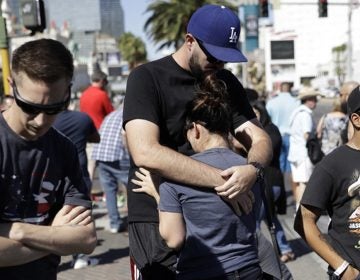 Reed Broschart, (center), hugs his girlfriend Aria James on the Las Vegas Strip in the aftermath of a mass shooting at a concert Monday, Oct. 2, 2017, in Las Vegas.