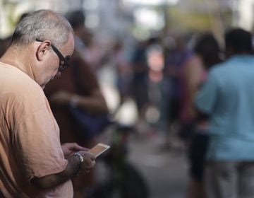 A man stands at a Wi-Fi hotspot in the aftermath of Hurricane Maria with many cellphone towers down in San Juan, Puerto Rico, Sunday, Sept. 24, 2017. (Carlos Giusti/AP Photo)