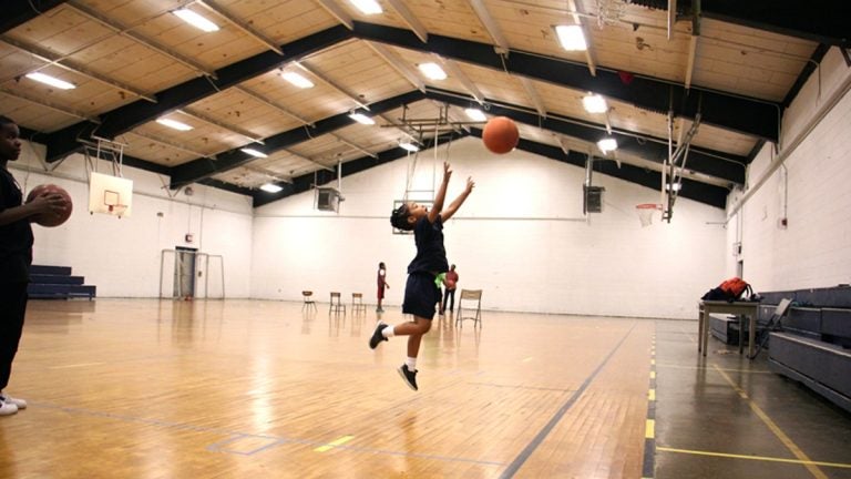 A little girl plays basketball in the gym during an afterschool program at Olney Rec Center