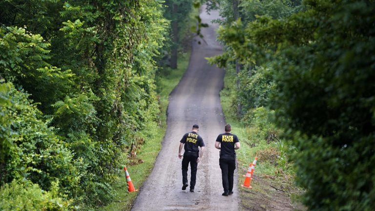 Pennsylvania State Police officers walk up a driveway, Friday, July 14, 2017, in Solebury, Pa. (AP Photo/Matt Rourke)