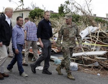 President Donald Trump takes a walking tour to survey hurricane damage and recovery efforts in a neighborhood in Guaynabo, Puerto Rico, Tuesday, Oct. 3, 2017. (AP Photo/Evan Vucci)