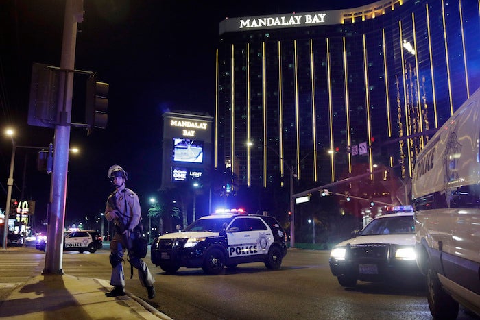 Police officers stand along the Las Vegas Strip the Mandalay Bay resort and casino during a shooting near the casino, Sunday, Oct. 1, 2017, in Las Vegas. (AP Photo/John Locher)