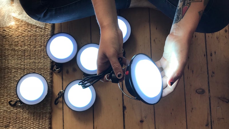 A person, out of view, sits crosslegged on the floor, showing the solar lights