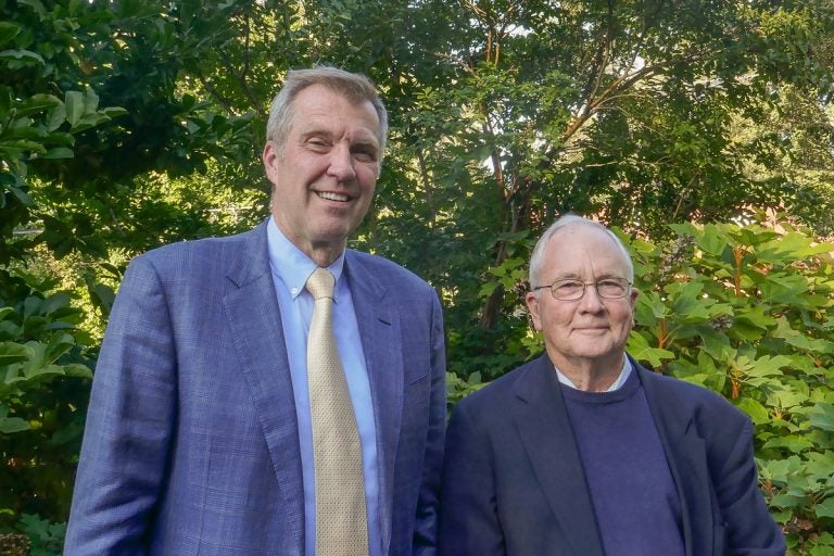 Two men pose for a picture, both in similar hues of purples