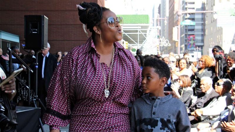 Jill Scott blows a kiss to the crowd gathered on South Broad Street to watch her plaque added to the Philadelphia Music Walk of Fame. With her is her son Jett Roberts, 8.