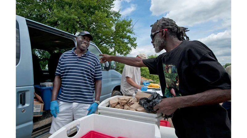 At the needle-exchange van in Camden in 2014, HIV-prevention team leader Sam Myers (left) talks with Nicholas Brown, who is exchanging syringes.  (April Saul for WHYY)