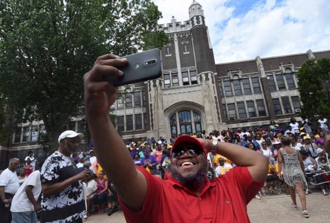 At a June 2017 barbeque to honor Camden High, alumnus John Royal takes a selfie as others assemble for a group photo.  (April Saul/for Newsworks)