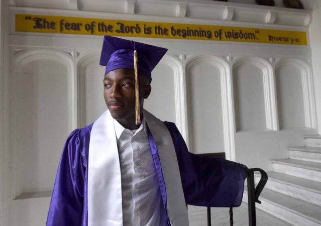 Julian Pratt waits to graduate from Camden High in the lobby in June 2016.  (April Saul/for Newsworks)