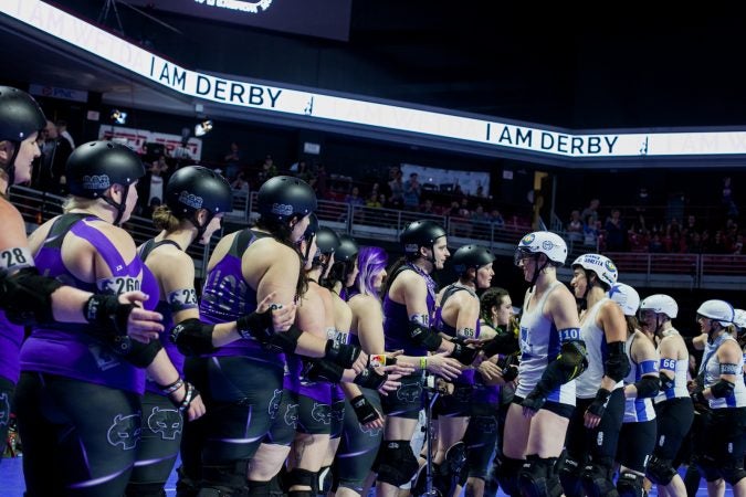 The new WFTDA International Champions, the Victorian Roller Derby League, shake hands with second place team, the Rose City Rollers. (Brad Larrison for WHYY)