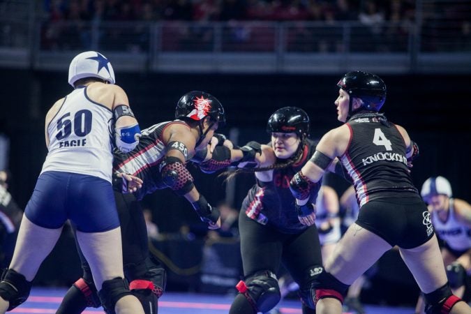 The Gotham Girls Roller Derby team, in black, vie against the Denver Roller Derby Team during the WFTDA International Championship at the Liacouras Center. (Brad Larrison for WHYY)