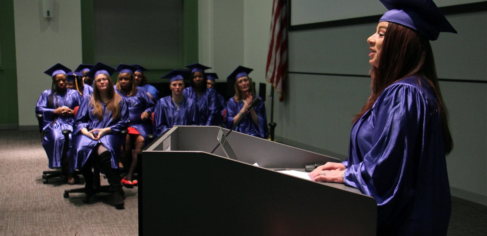 Redina Rodriguez (center) delivers her graduation speech at the Women Working 4 A Change re-entry program graduation ceremony.