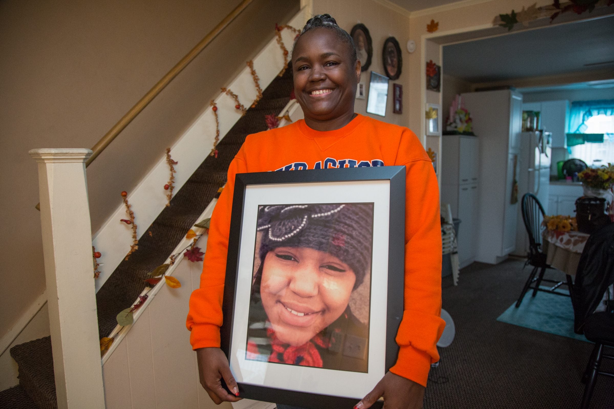 Anita Mason holds a photo of her late daughter, Robin West, in her Upper Darby home.