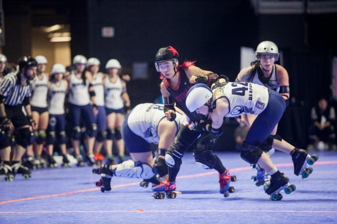 The Gotham Girls Roller Derby team, in black, vie against the Denver Roller Derby Team during the WFTDA International Championship at the Liacouras Center. (Brad Larrison for WHYY)